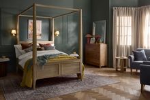 Wooden Newton four-poster bed with bedding.