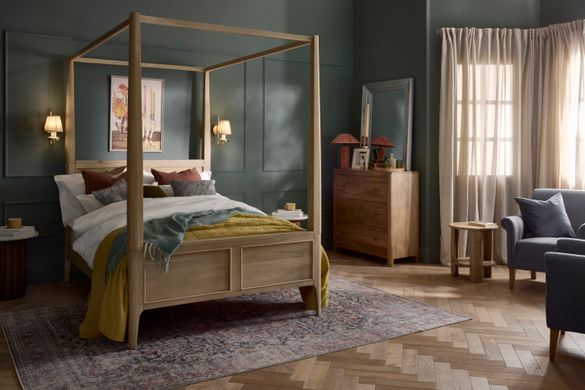 Wooden Newton four-poster bed with bedding.
