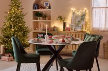Elegant dining table set with green chairs and festive table decorations.