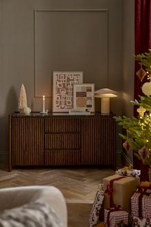 Modern dark wooden sideboard with decorative grooves and black marble top