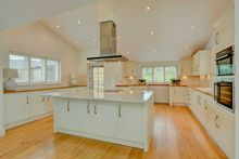 Modern kitchen with a central island and built-in stainless steel appliances.