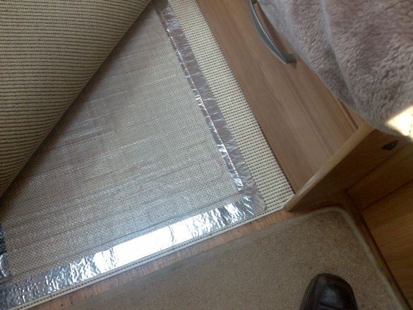 The RugBuddy is shown on its underlay, on the floor, with the covering mat pulled back to top right 